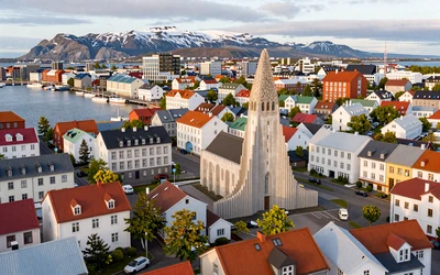 Colorful Reykjavik rooftops with Hallgrimskirkja church and snowy mountains