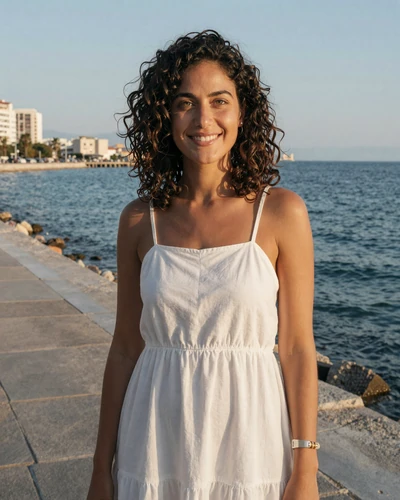 Dimitra, 26, Greek woman from Thessaloniki smiling on the waterfront promenade