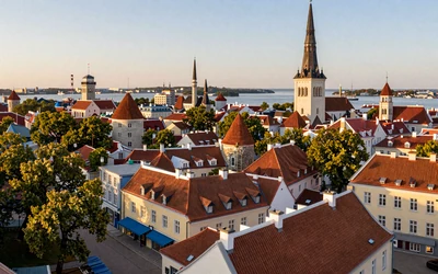 Aerial view of Tallinn Old Town with red rooftops and harbor in golden light